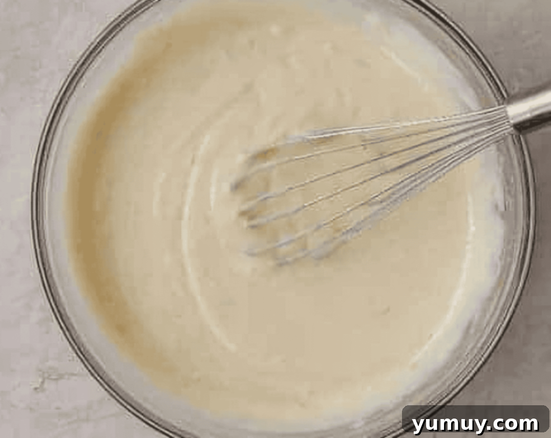 Sunshine Slice 10 key lime pie filling in a glass bowl being whisked.