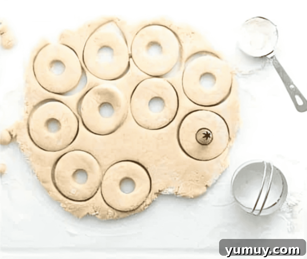 cutting out doughnuts from dough.