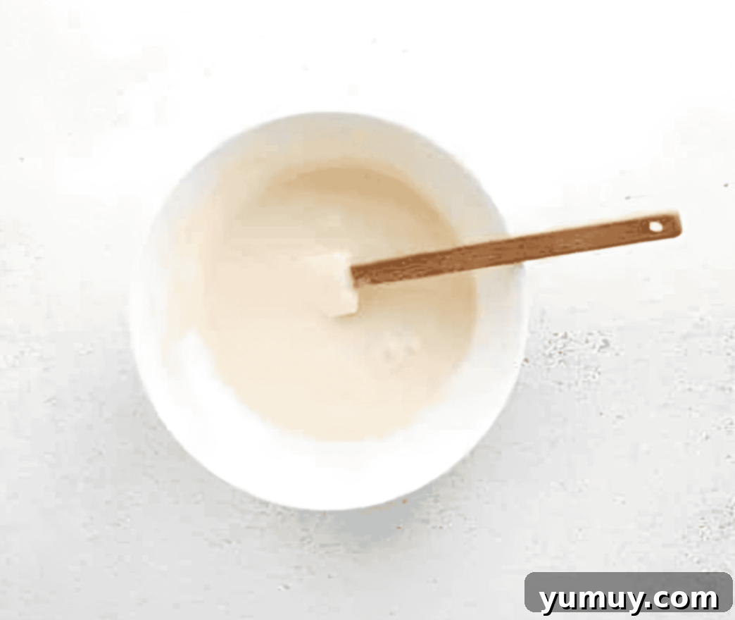 glaze in a white bowl with a rubber spatula.