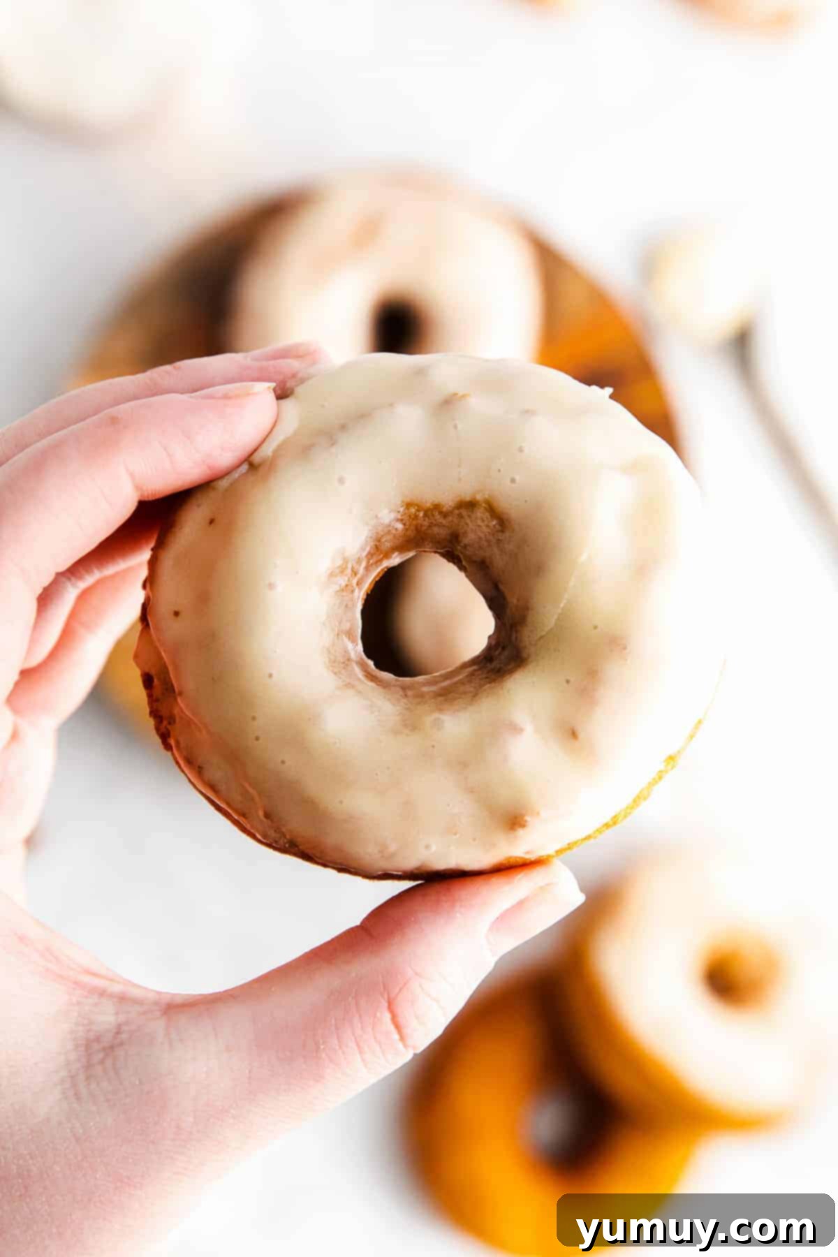 holding up a glazed donuts