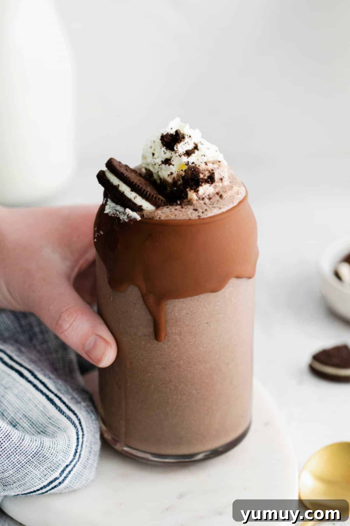 Creamy Oreo Dream 2 A rich, chocolate-covered glass holding a creamy Oreo milkshake, topped with whipped cream and crushed Oreos.