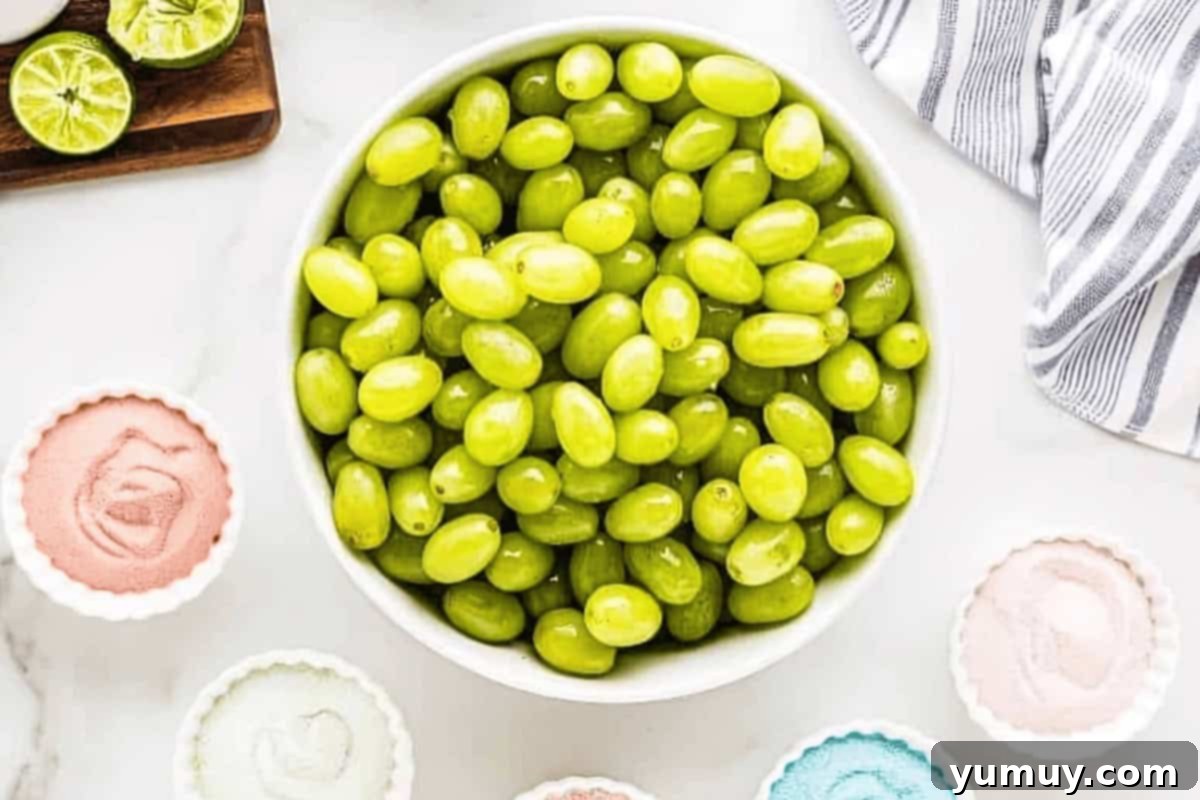 green grapes in a bowl surrounded by smaller bowls of jello powder.