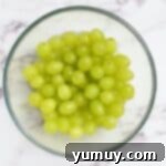 Green grapes soaking in a glass bowl.