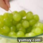 Piercing a grape with a toothpick.