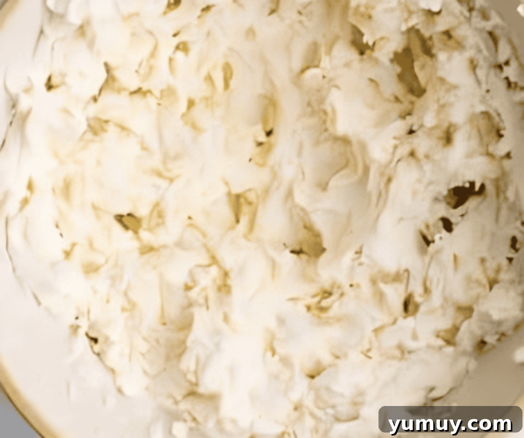 Creamed butter and sugar in a mixing bowl, showing a light and fluffy texture.