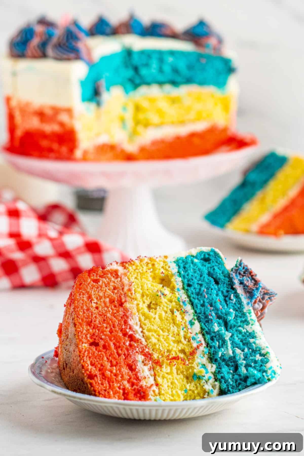 A vibrant slice of red, white, and blue layer cake, showcasing distinct patriotic layers with creamy frosting.