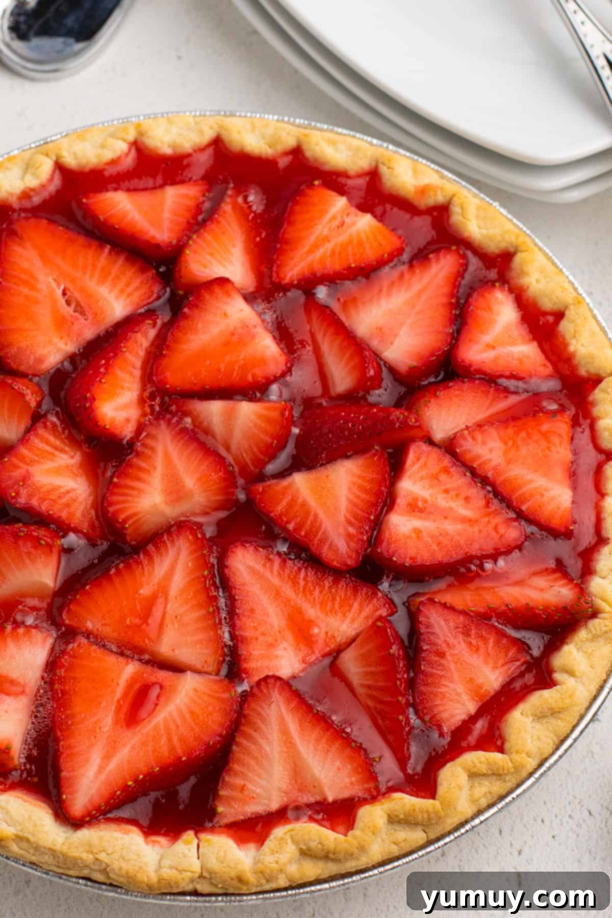 An overhead view of a refreshing strawberry jello pie with a fluffy whipped topping, served in a classic pie plate.