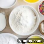 Luscious Vanilla Sheet Cake 5 measured ingredients for vanilla sheet cake in individual bowls.