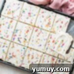 Luscious Vanilla Sheet Cake 10 sliced vanilla sheet cake topped with frosting and sprinkles.