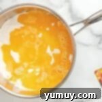 Fun Fragrant Kool Aid Playdough 6 Water and oil added to a pan of Kool-Aid powder and dry ingredients, being stirred.