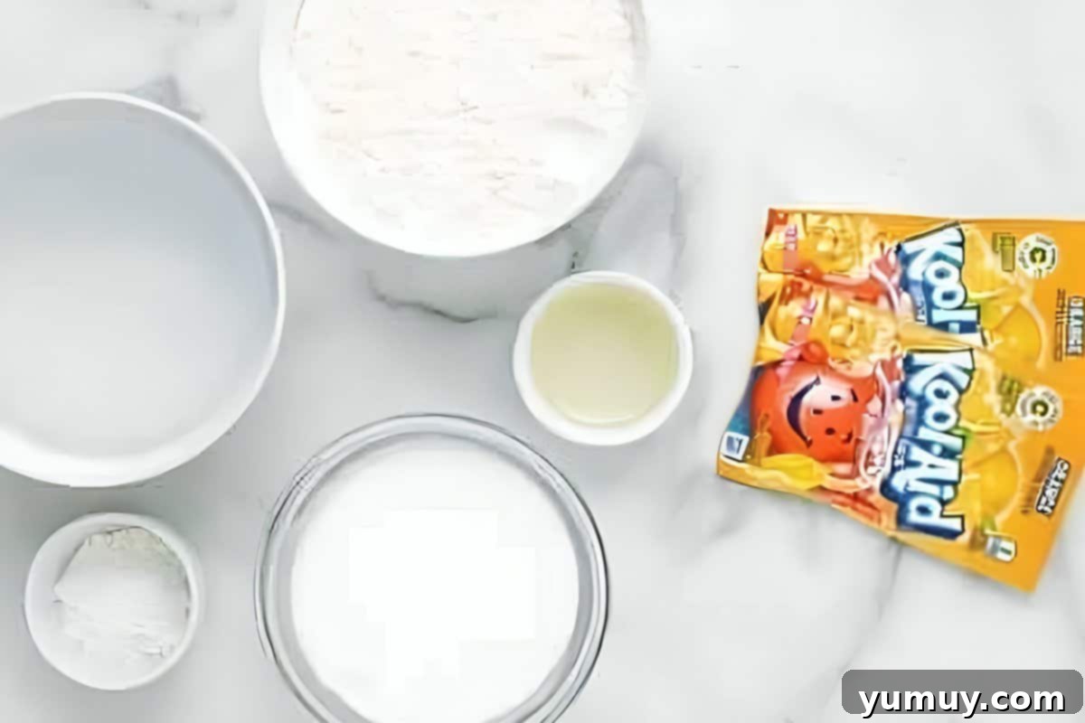 Fun Fragrant Kool Aid Playdough 9 Organized ingredients for homemade Kool-Aid playdough on a clean surface, including flour, salt, cream of tartar, Kool-Aid packets, water, and oil.