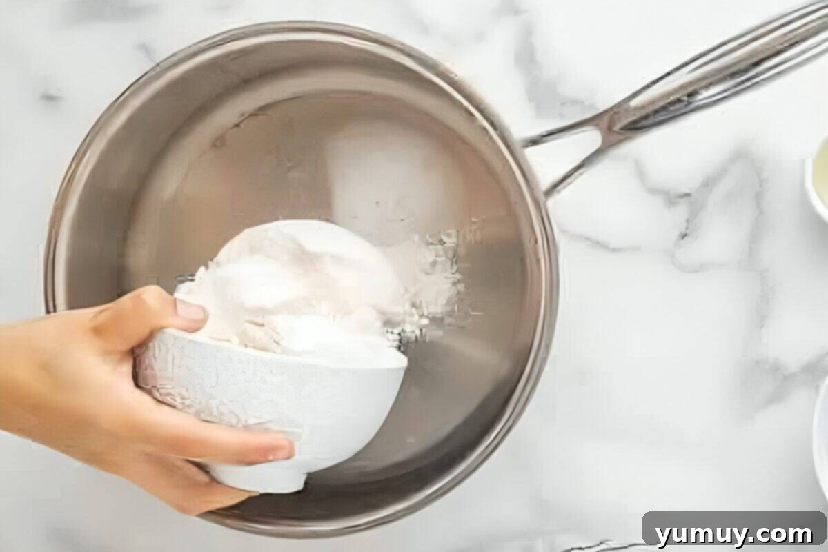 Fun Fragrant Kool Aid Playdough 10 Pouring flour into a saucepan to begin the homemade playdough recipe.