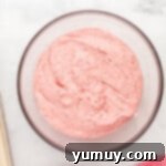 strawberry cake batter in a bowl on a marble countertop.