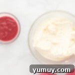 a bowl of whipped cream and a bowl of raspberry sauce.