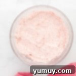 strawberry icing in a glass bowl with a pink towel.