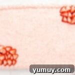 a strawberry cake with frosting and strawberries on a white plate.