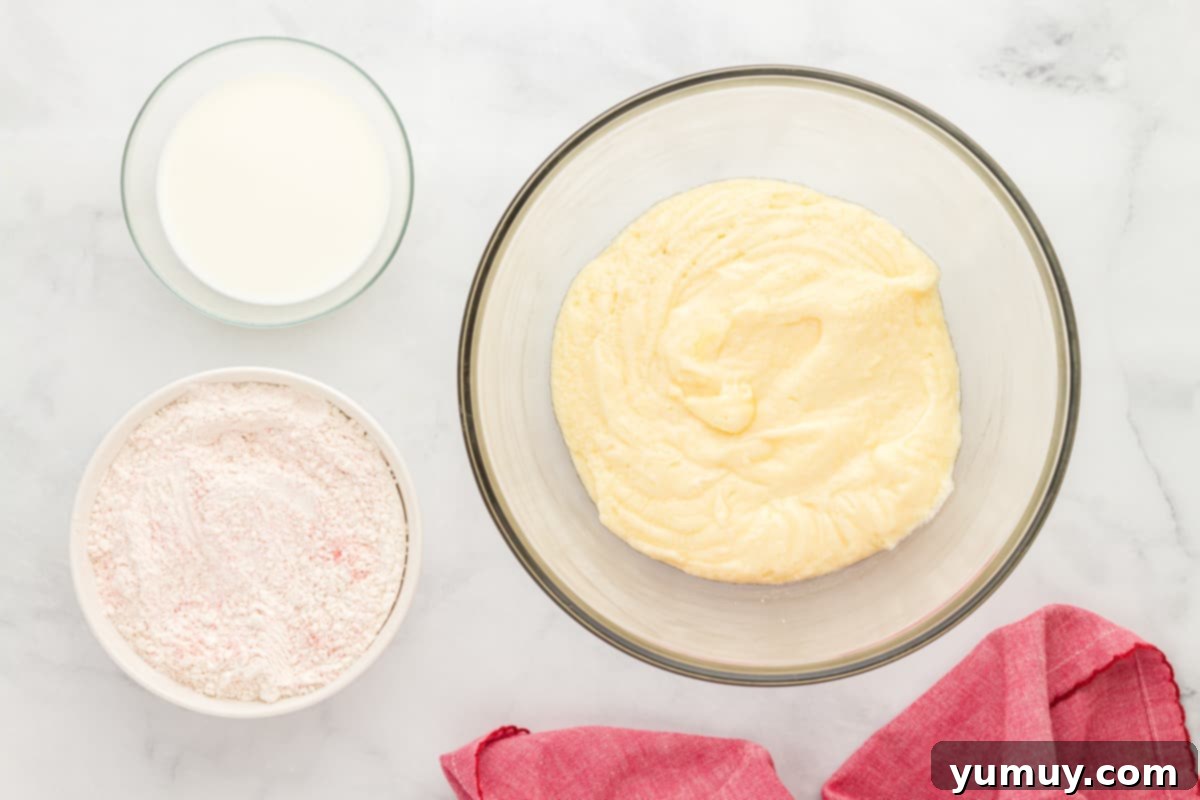 a bowl of flour, eggs and milk on a marble table.