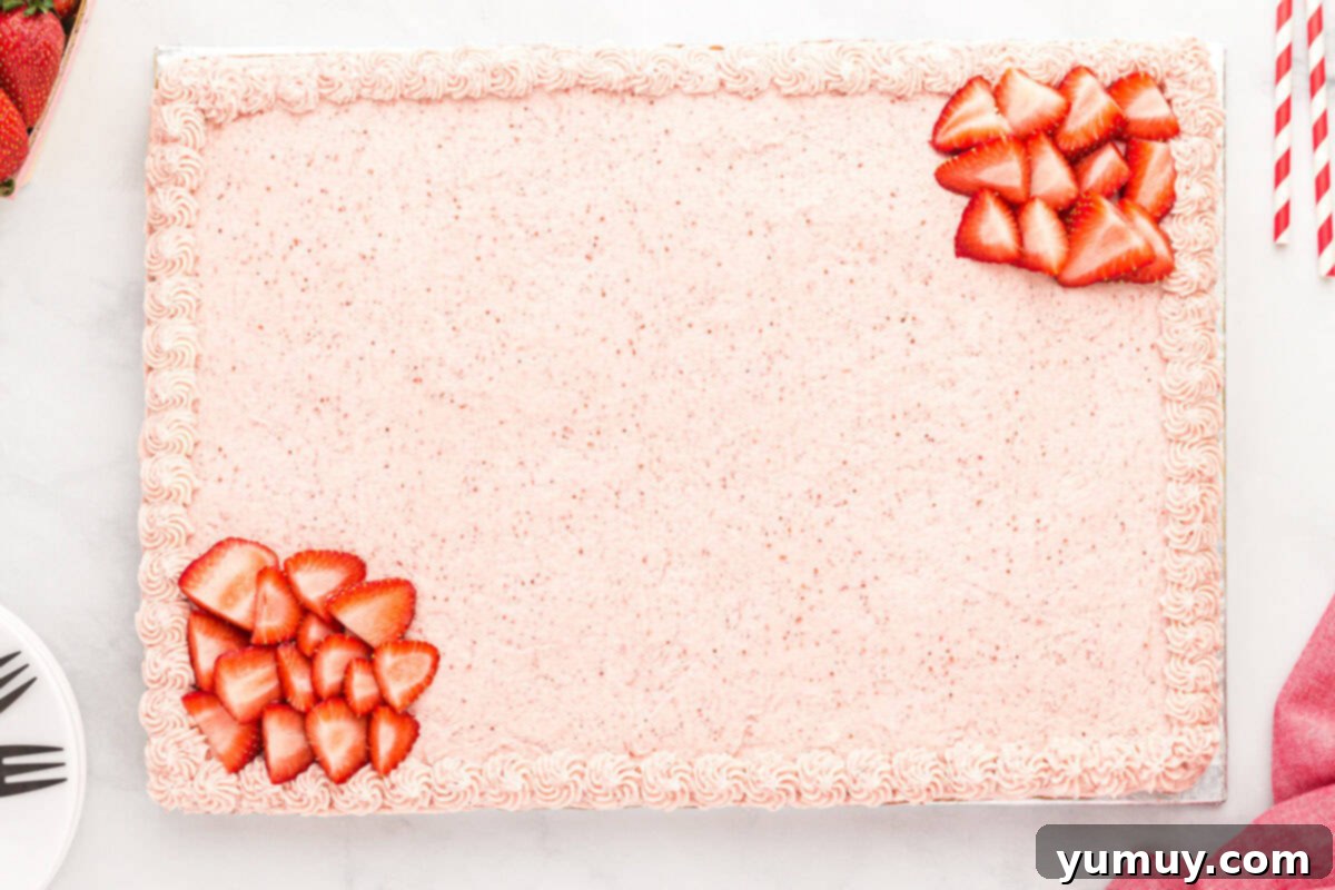 A frosted and decorated strawberry sheet cake.