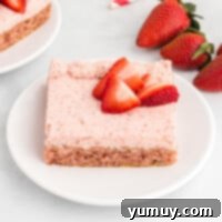a slice of strawberry cheesecake on a white plate.