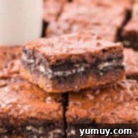 A stack of Slutty Brownies, showing the layers of cookie, Oreo, and brownie, ready to be enjoyed.