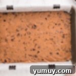 Chocolate chip cookie dough pressed into the bottom of a baking pan.