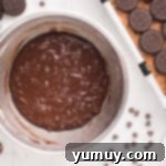 Brownie batter being mixed in a bowl with eggs, butter, and milk.