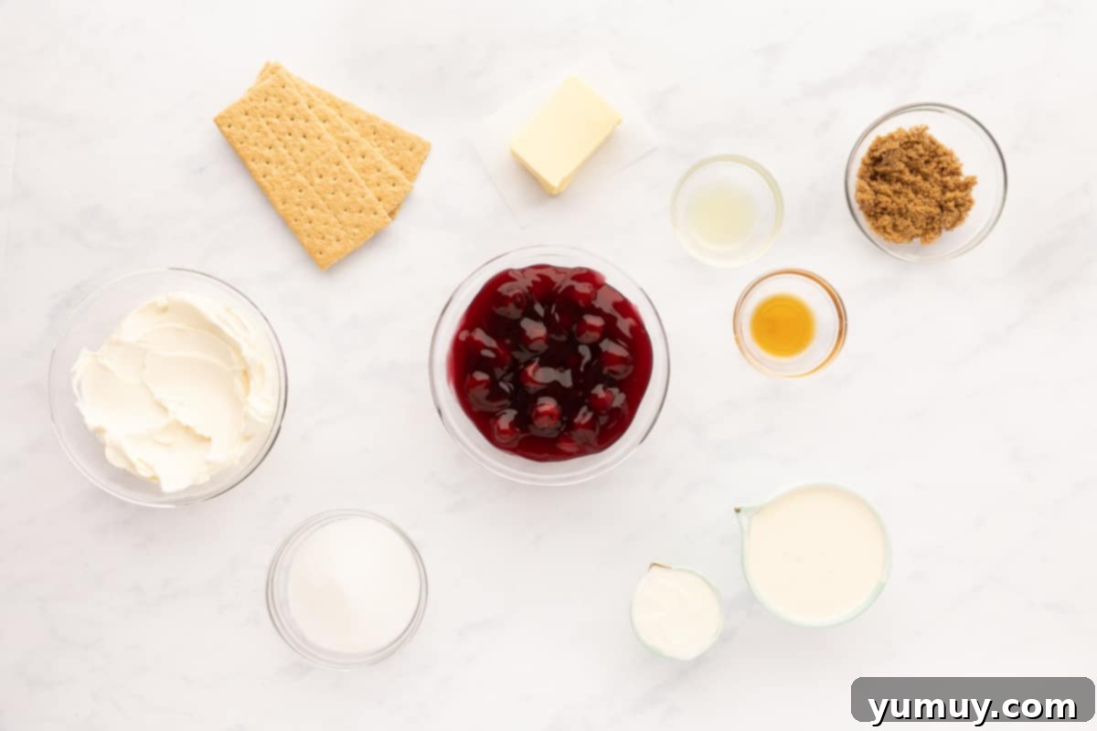 All the fresh ingredients laid out on a marble countertop, ready for making no-bake cherry cheesecake.