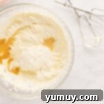 Sour cream, vanilla, and lemon juice added to the cream cheese mixture, being gently combined with a hand mixer.