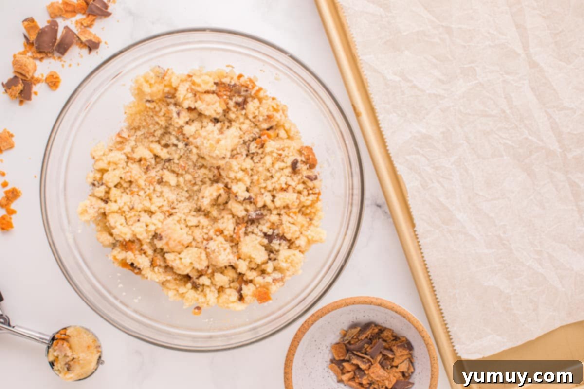 Cookie dough with chopped Butterfinger candy, ready to be scooped onto a baking sheet.