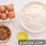 A bowl of dry ingredients for cookies next to a whisk, illustrating the first step of preparation.