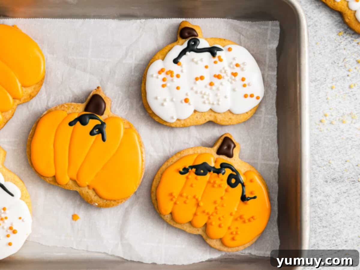 Effortless Pumpkin Puree Delights 4 pumpkin sugar cookies, some with orange frosting, some with white frosting