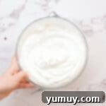 stabilized whipped cream frosting in a glass bowl.