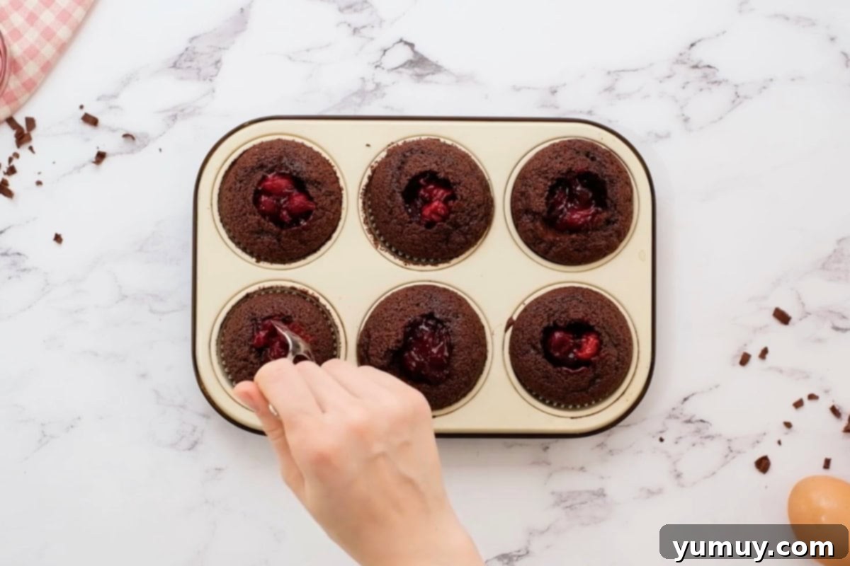 filling chocolate cupcakes with cherry pie filling.