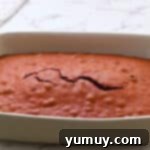 Freshly baked red velvet cake in a 9x13-inch baking dish, still warm from the oven and smelling delicious.