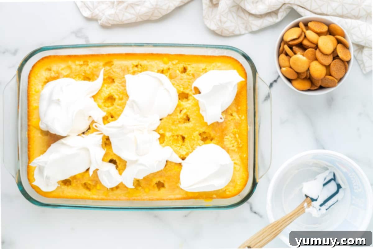 whipped cream on top of cake in a glass baking dish
