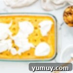 whipped cream on top of cake in a glass baking dish
