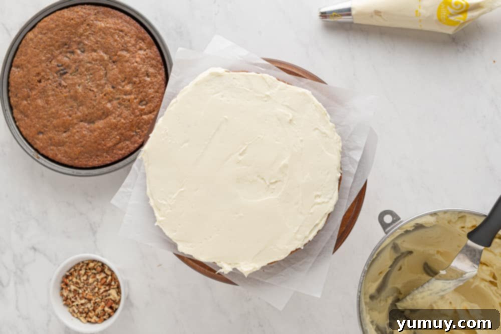 a cake with icing and ingredients on a table, showcasing the layering process.