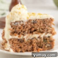a delicious slice of orange carrot cake on a plate, ready to be enjoyed.