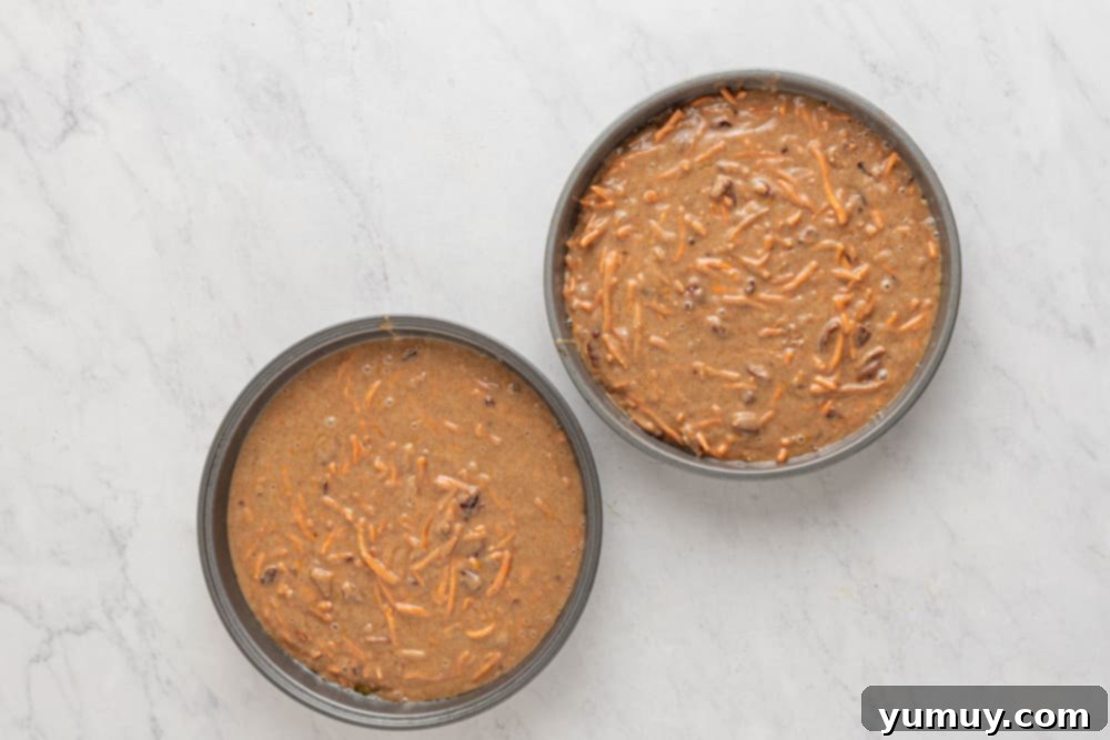two bowls of brown food, showing the mixed carrot cake batter with pecans and orange zest.