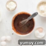 chocolate cake ingredients being stirred in a bowl