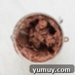 Velvety chocolate frosting in a mixing bowl, perfectly whipped and ready for cake assembly.