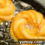 Crispy Chocolate Cruller Twists 11 crullers frying in a pot of oil