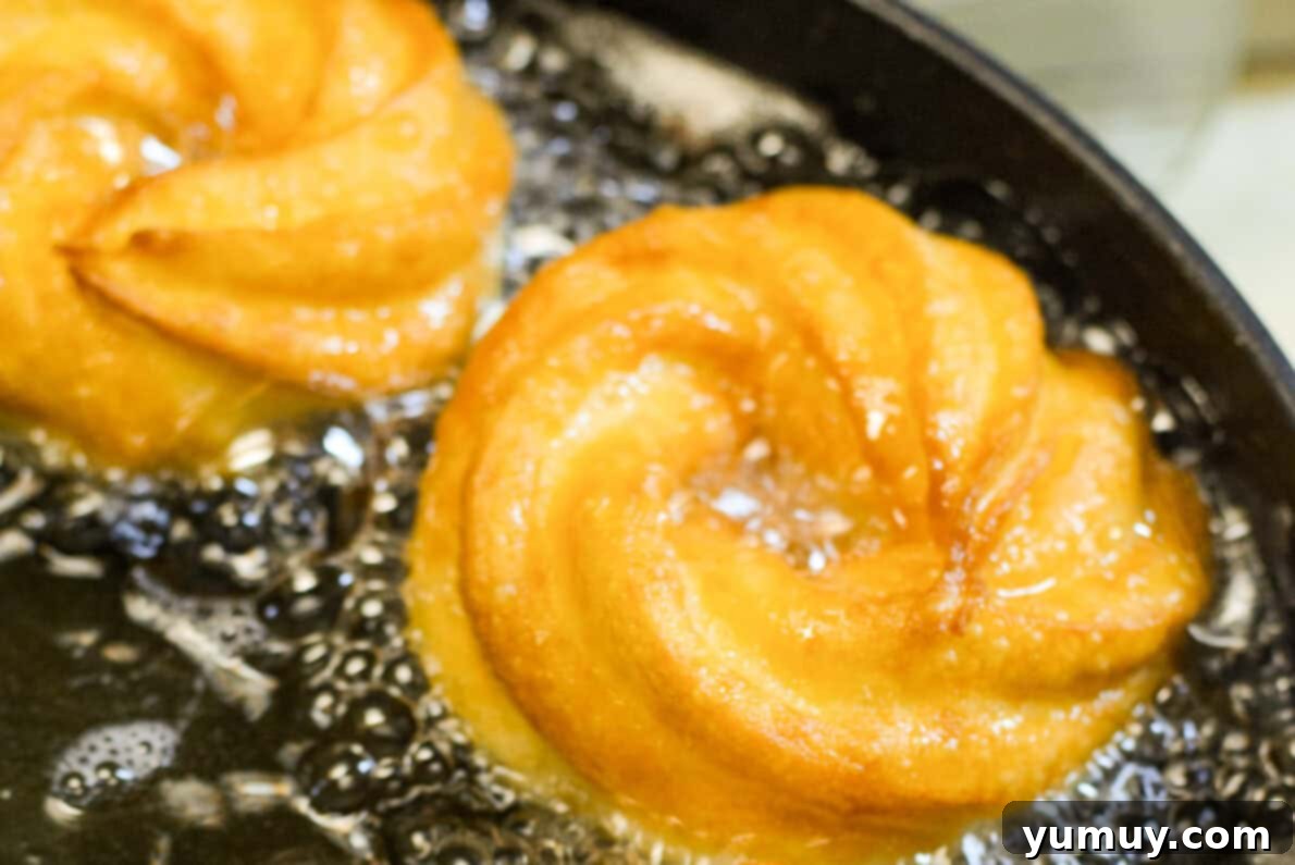Crispy Chocolate Cruller Twists 20 crullers frying in a pot of oil