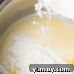 Crispy Chocolate Cruller Twists 6 adding flour to wet ingredients in a metal bowl