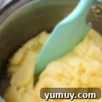 Crispy Chocolate Cruller Twists 7 cruller dough in a metal bowl with a blue spatula