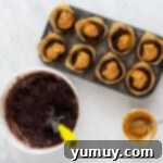 peanut butter spooned onto chocolate muffin batter in a muffin tin