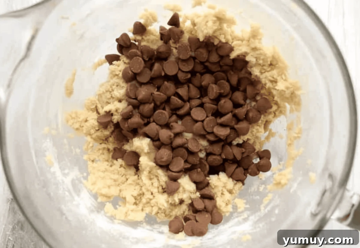 cookie dough dip with chocolate chips on top in a glass bowl.