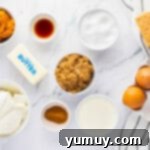 A springform pan meticulously wrapped in multiple layers of aluminum foil, ready for a water bath, with a backdrop of a preheated oven.