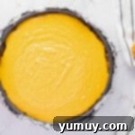 The smooth, unbaked pumpkin cheesecake batter filling a foil-wrapped springform pan, resting on a baking sheet.