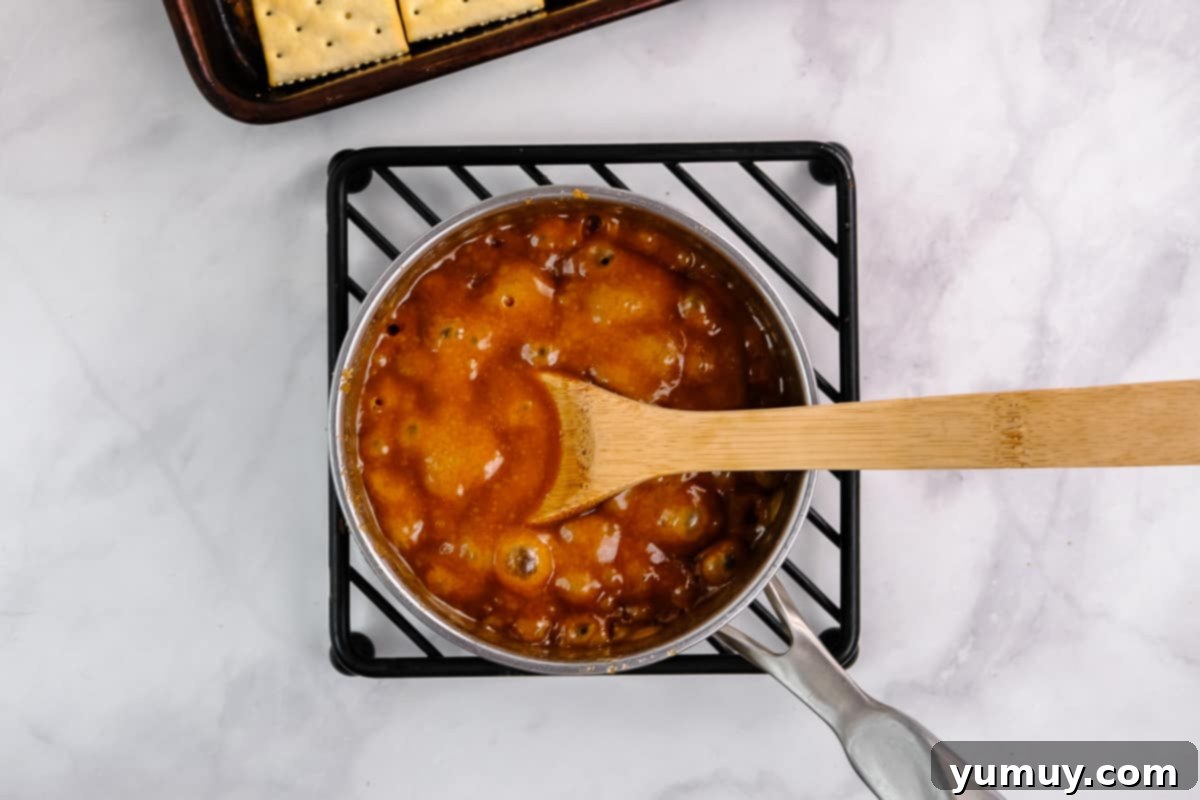 Yuletide Toffee Obsession 7 bubbling caramel in a pot with a wooden spoon.